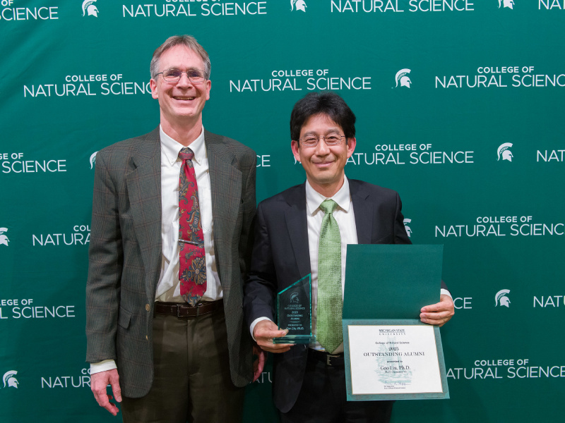 dean eric hegg standing with alumni award winner