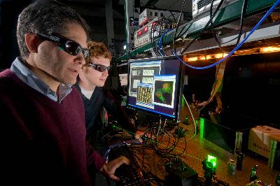 Marcos Dantus and a graduate student in his lab looking at data from a security laser.