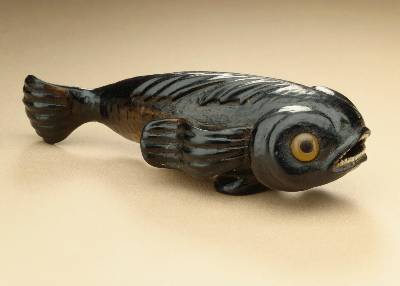 An image of a fish carving, made in Japan in the 19th century, is crafted from black persimmon wood that’s gained strength and a dark coloration from microbes living within the wood pores.