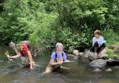 Three MSU students who participated in the summer 2022 Plant Systematics Field Course out in the field at KBS identifying plants and habitats. 