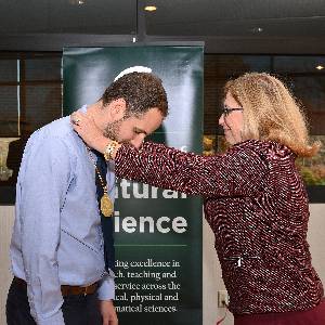 Francois Greer receives his endowed faculty medallion from MSU Interim President Teresa K. Woodruff.