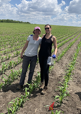 Sarah Evans (left) and LTER graduate student Corinn Rutkoski are posing for a photo in an agricultural field where they are collecting soils to examine what microorganisms degrade pesticides.