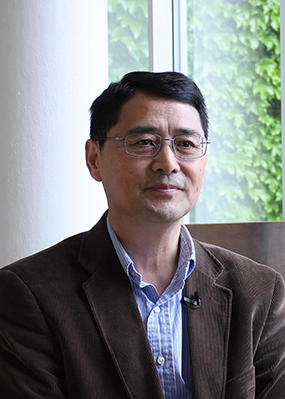 Headshot of Guowei Wei in Wells Hall on the MSU campus