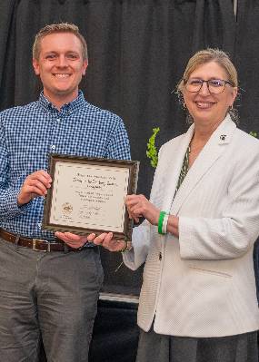 Joespeh Riedy poses with MSU Intermin President Teresa Woodruff with his Excellence-in-Teaching Citation.