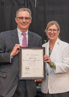Robert Maleczka poses with MSU Interim President Teresa Woodruff with his award plaque.