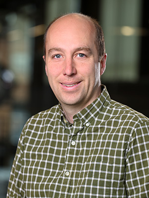 Headshot of Nathan Whitehorn in a brown plaid shirt.