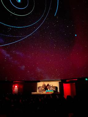 A storyteller performing on stage at the Abrams Planetarium as part of an offering to the general public.