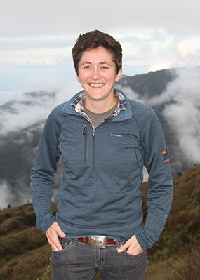 Sarah Fitzpatrick standing outside in a blue fleece with mountains in the background.