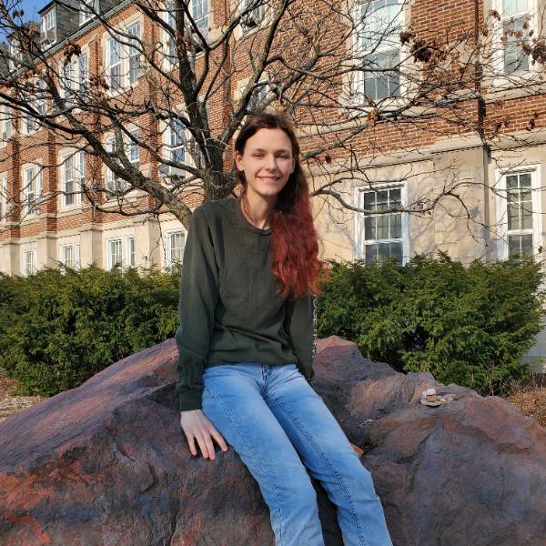 Libby Ashby sits on Banded iron Formation in front of the MSU Natural Science Building