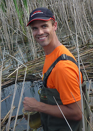 Anthony Kendall wearing waders in a marsh