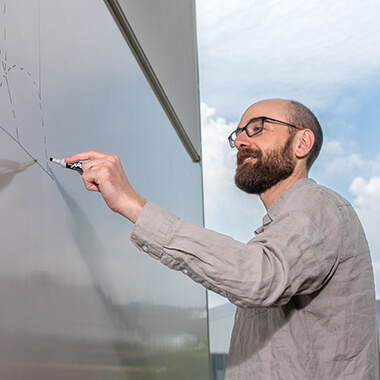 Preston Wake draws a graph on a whiteboard.