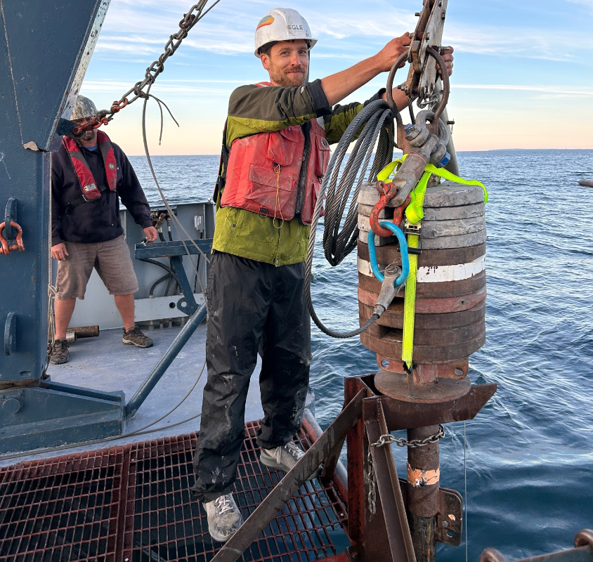 Dalton Hardisty is dressed in safety gear and works on the deck of a ship securing a cable
