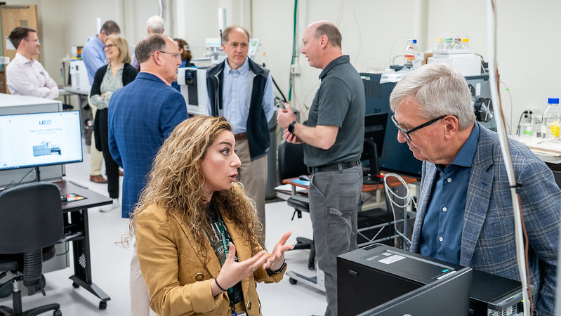 MSU leaders visit the Mass Spec and Metabolomics Core. Maryam Goudarzi (left, tan blazer) speaks with Doug Gage (right, blue checkered suit coat.)