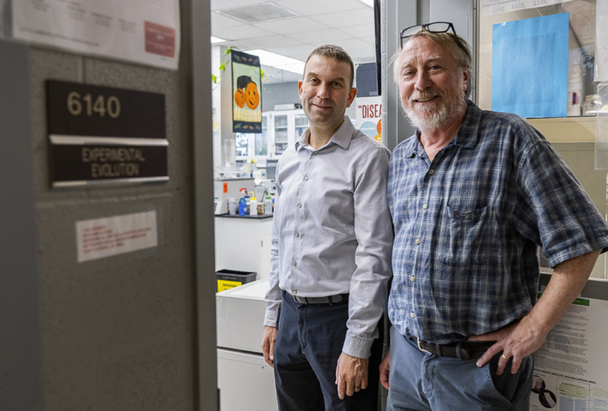 Jeffrey Barrick and Richard Lenski stand at the door to their lab.
