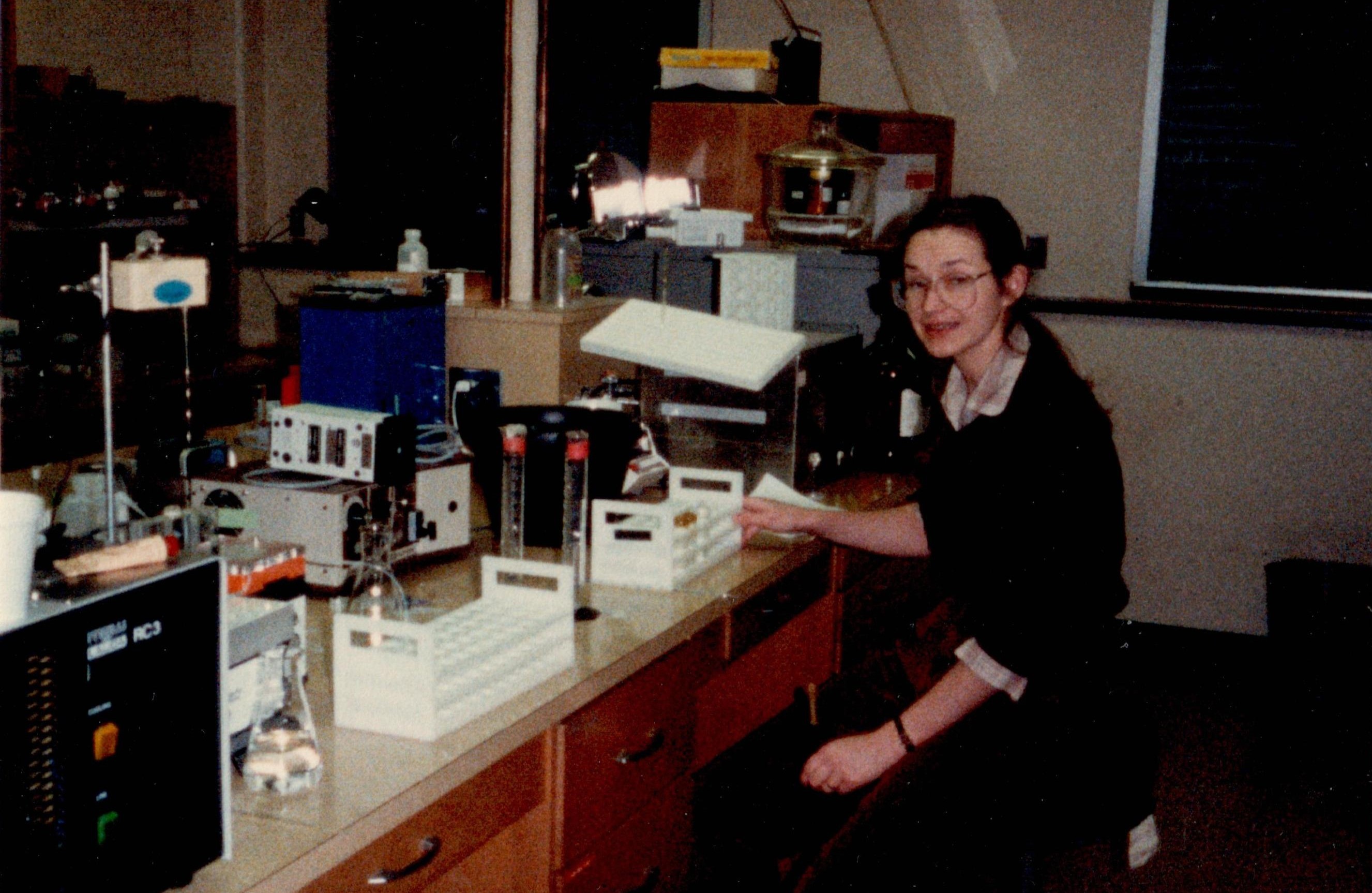 A photo from the 1980s depicting a woman working in a lab