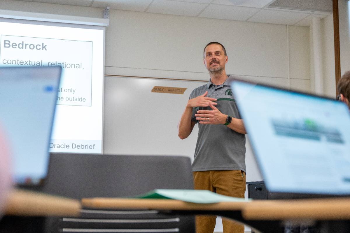 Faculty member stands in front of class to answer questions