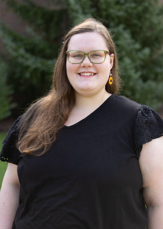 head and shoulders photo of woman with long hair wearing glasses