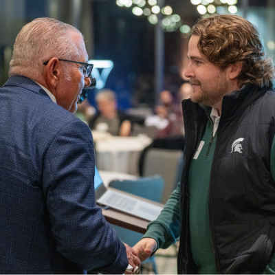 Two men shaking hands at an indoor event