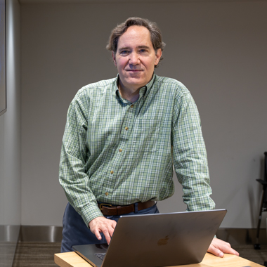 A man stands in front of a computer