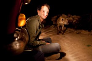 Image of Eli Strauss in field with hyenas