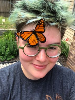 Image of Erica Fischer with butterfly on her head.