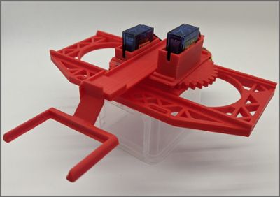 The fully assembled PiAutoStage device made from red plastic. Blue servo motors are in the housings in the device.