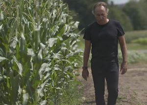 Bruno Basso wlaking in a cornfield with drone behind him