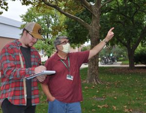 Noel Sheffer (left) learns the importance of field work and the scientific method in the class of Andrew Jarosz (right) by estimating color changes and leaf drop.