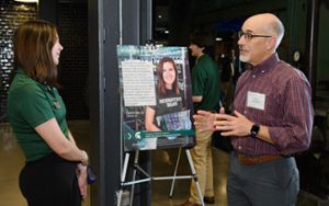Kyle Lewallen talking with Dean's Research Scholar Christina Liu by her presentation poster.