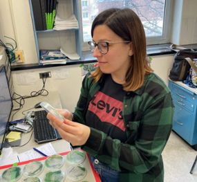 Maria Santos Merino sitting in her lab looking at samples