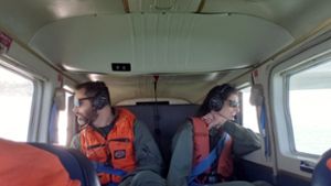 Wildlife biologist Nick Wirwa and MSU Ph.D. student, Kayla Davis, seated in a plane collecting data during an aerial waterbird survey.