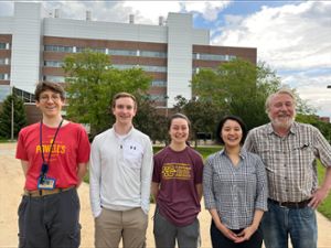 Group photo of Richard Lenski and his lab members outside of MSU's Biomedical and Physical Science's Building, the home of the LTEE experiment.