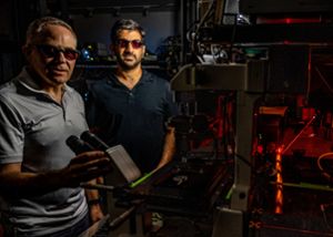 MSU researchers Marcos Dantus and Elad Harel standing in the laser lab dark room